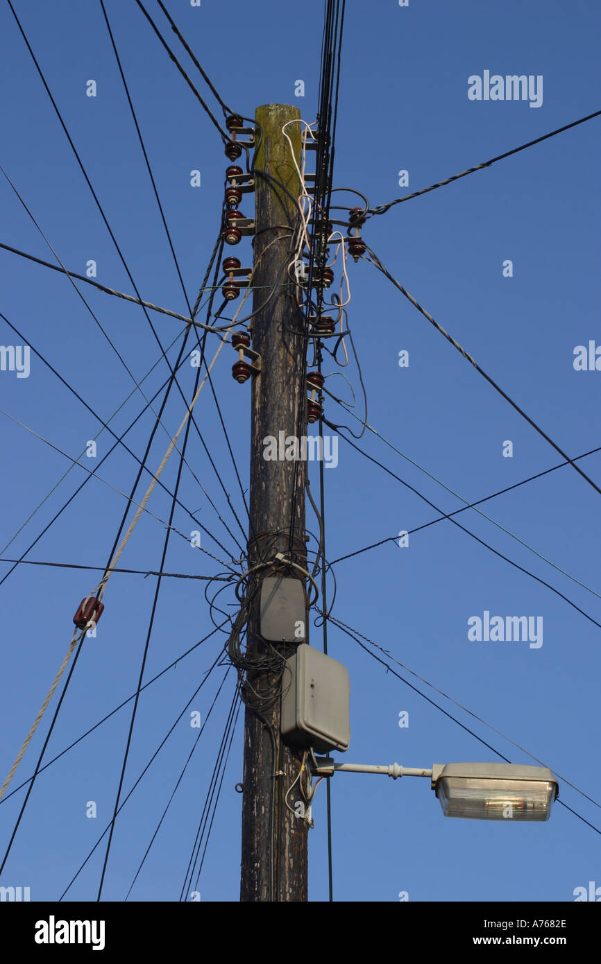 Overloaded telephone wires on wooden telegraph pole England Stock Photo