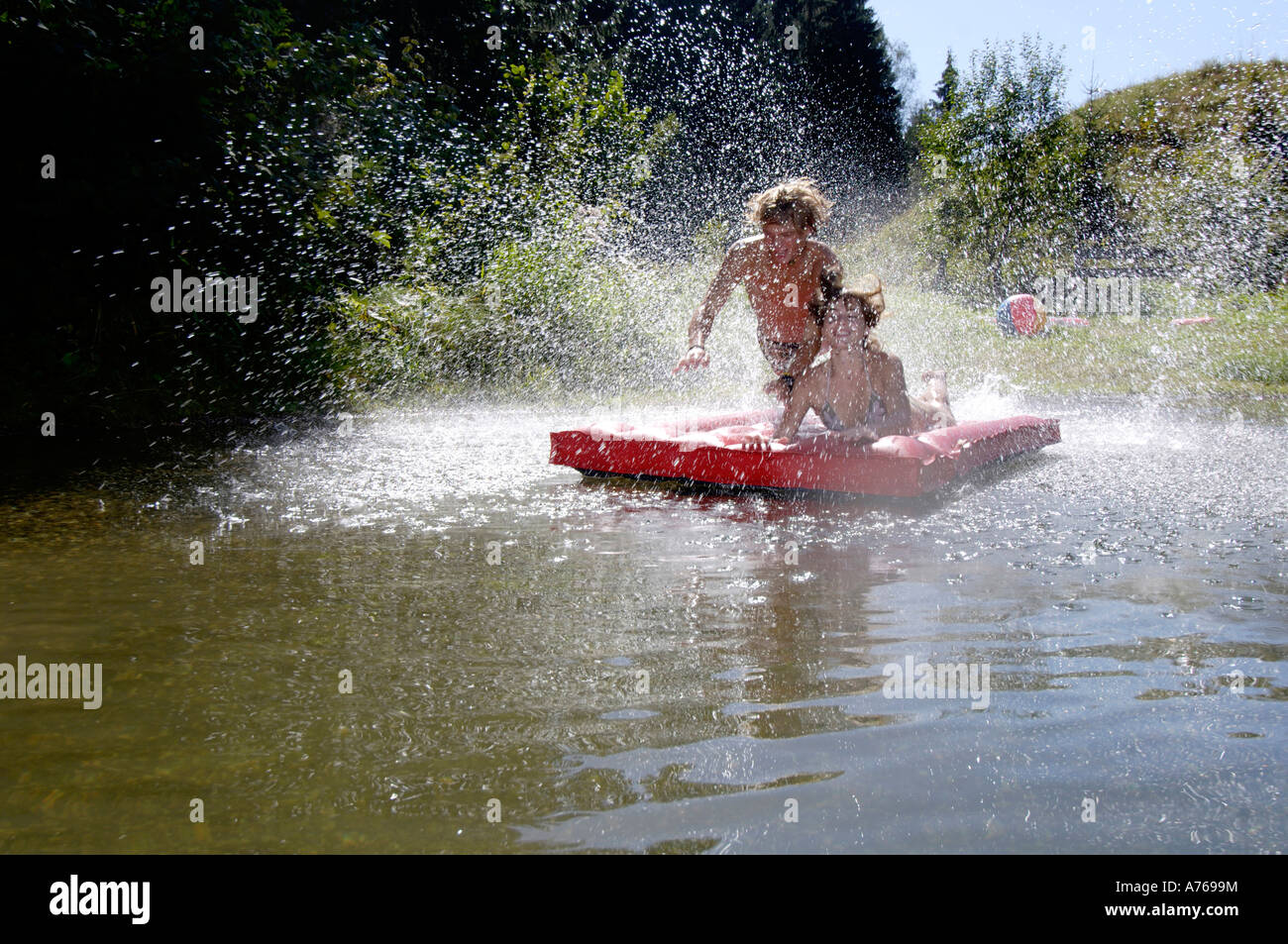 Young couple jumping on air mattress Stock Photo Alamy