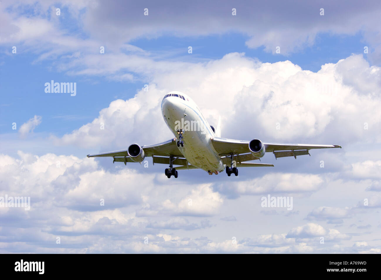Close up view of a passenger jet landing at an airport with the flaps and landing gear down. Stock Photo