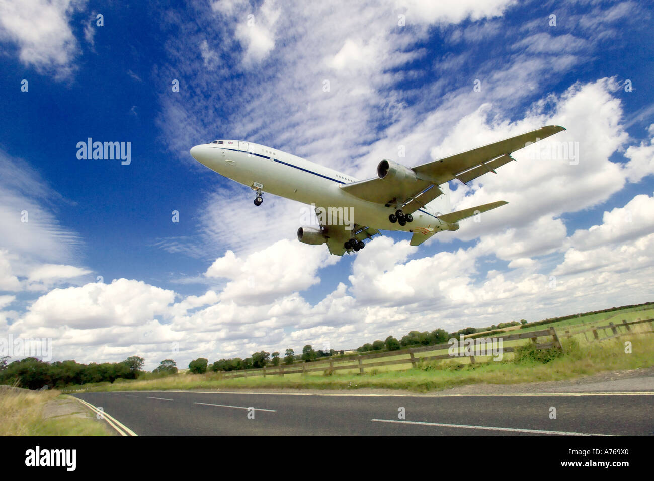 Close up wide view of an aircraft landing at an airport with the flaps, landing gear down and the ground in view. Stock Photo