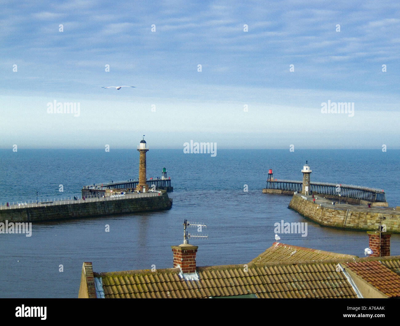 Elevated view from the East cliff of Whitby of the East and West piers and their lighthouses with the North Sea disappearing into the horizon. Stock Photo