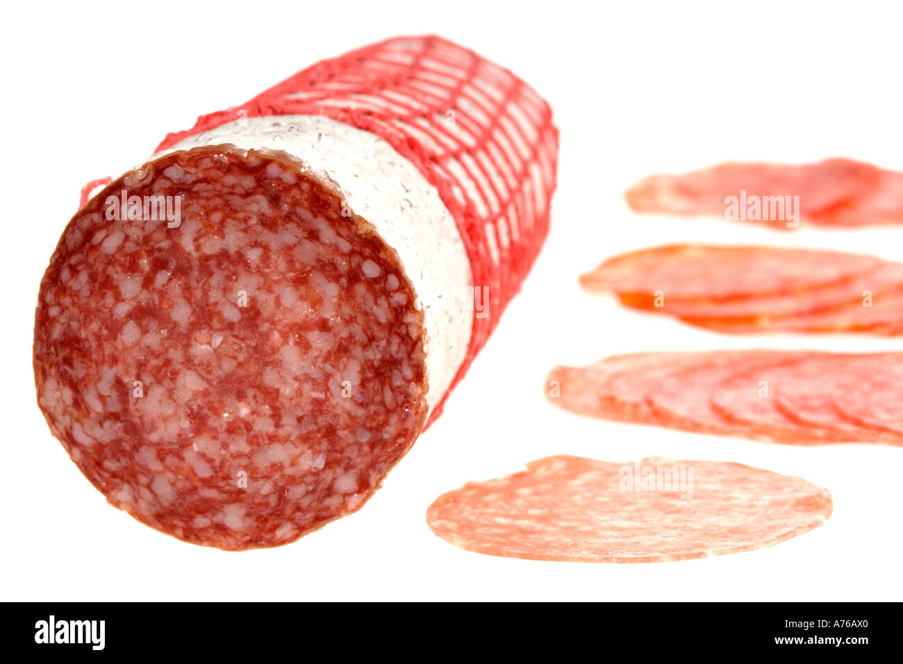 A whole Sopressata Italian salami sausage and slices of different Stock