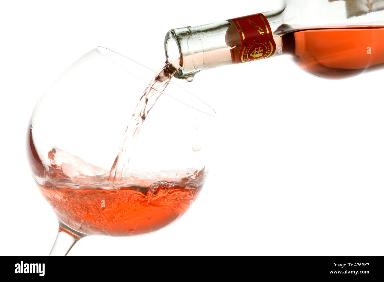 Rose wine being poured into a large glass on a pure white background Stock Photo - Alamy