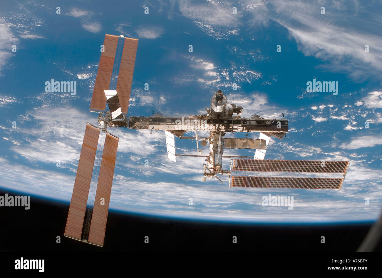 Backdropped by a blue and white Earth, the International Space Station ...