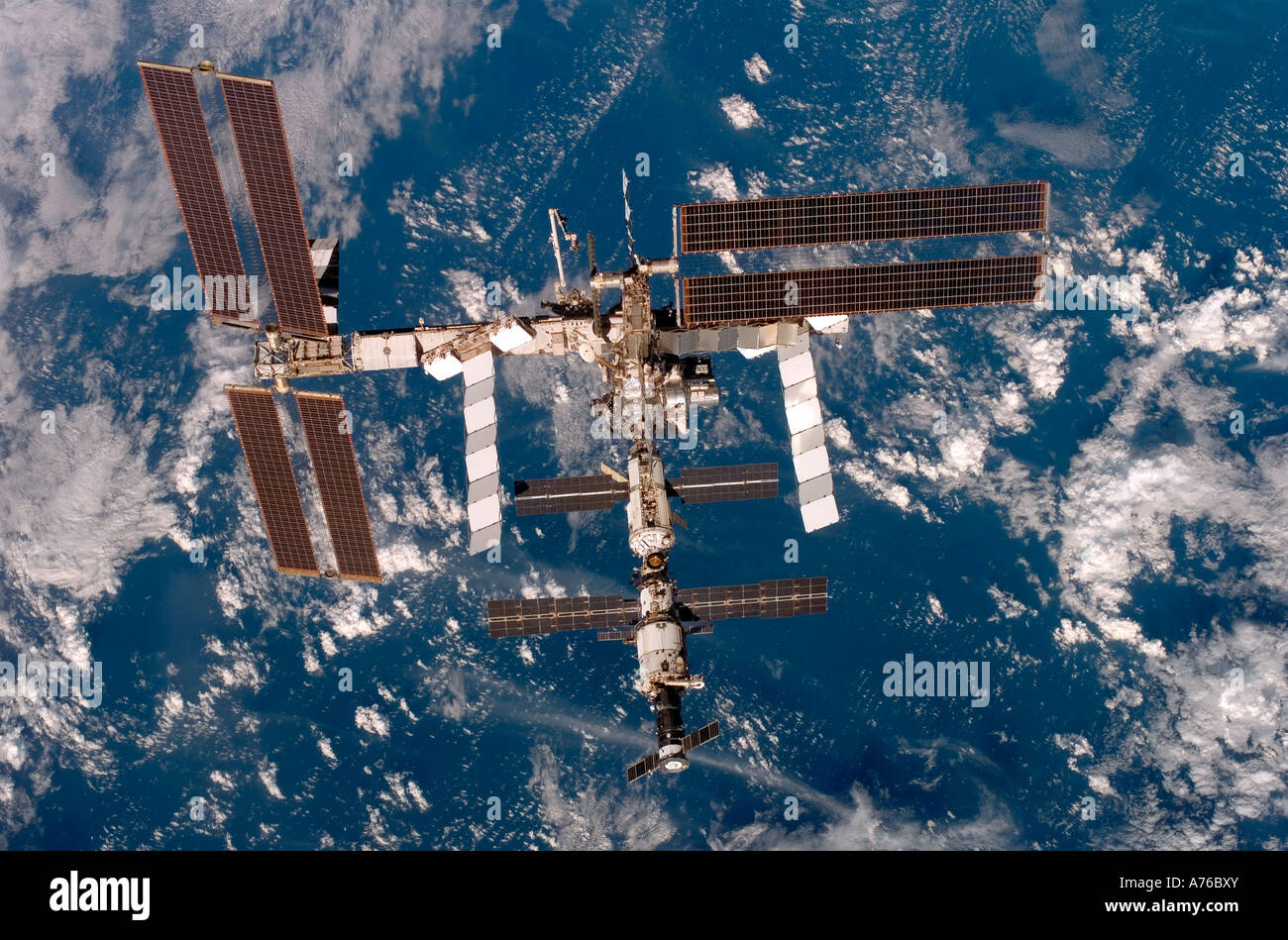 Backdropped by a blue and white Earth, the International Space Station ...