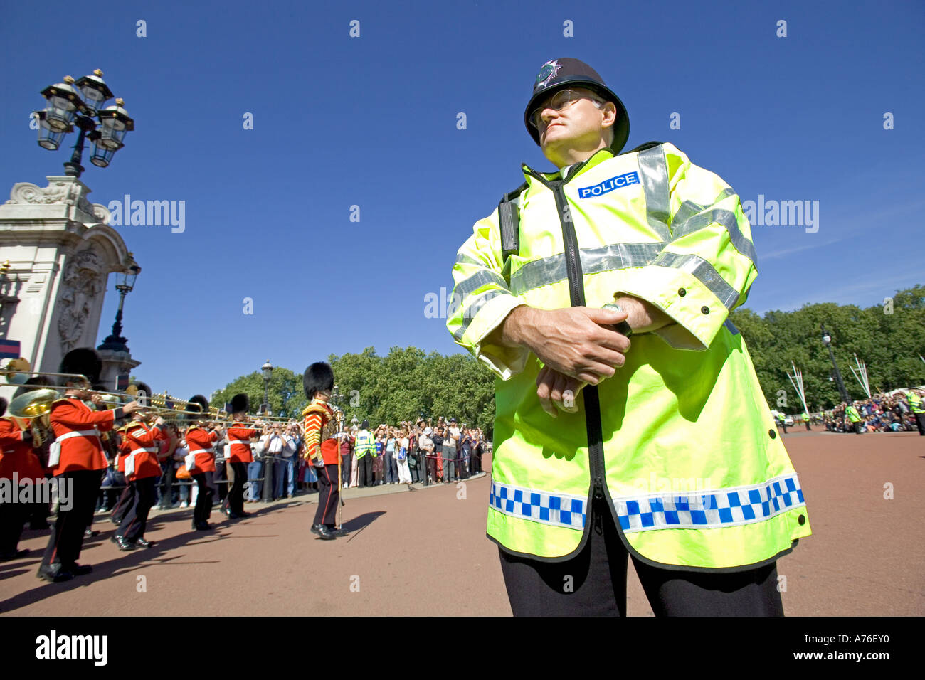 Close focus wide angle of a policeman keeping an eye over the crowds watching the Changing of the Guard ceremony in London. Stock Photo
