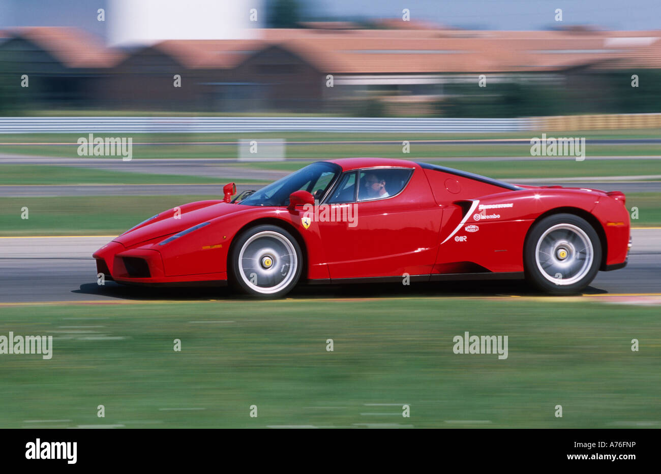 Red Enzo Ferrari driven at speed around Ferrari test track at Fiorano near Maranello Italy Stock Photo