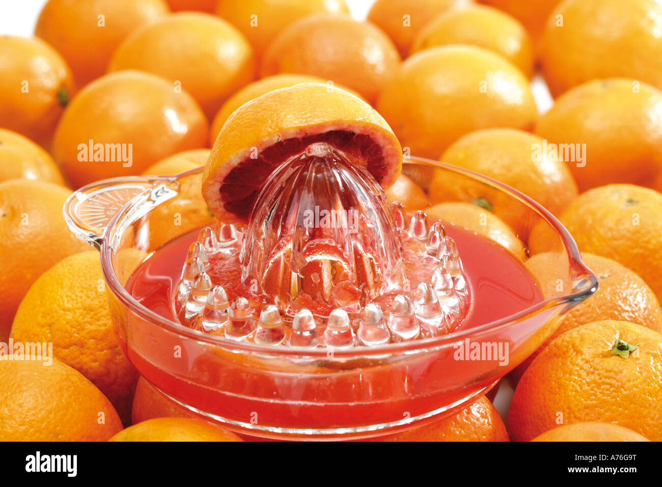 Squeezer with halved blood orange on orange fruits Stock Photo
