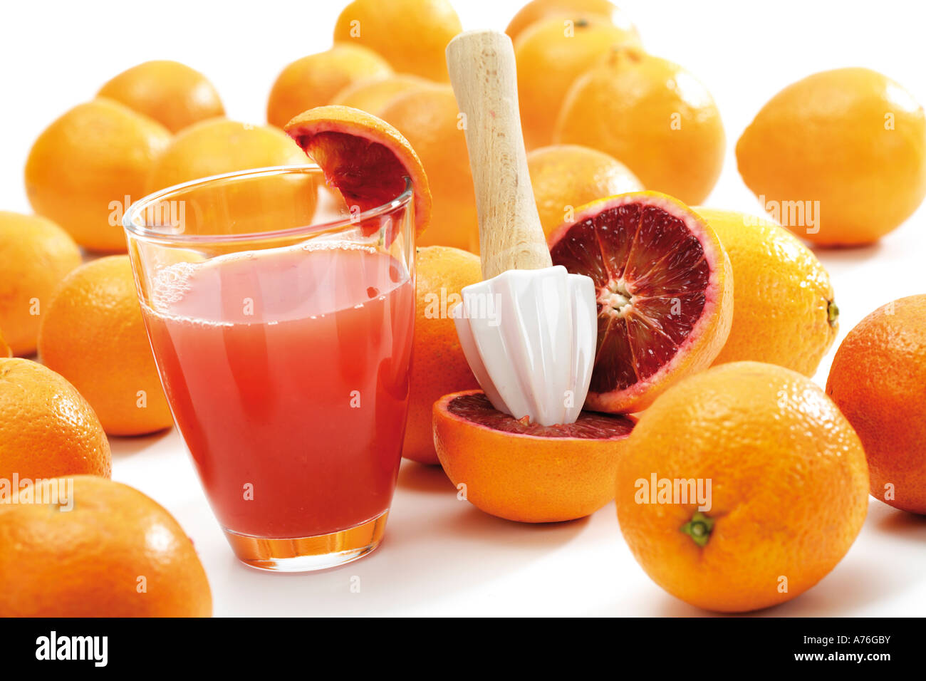 Squeezer on sliced blood orange and glass of juice Stock Photo