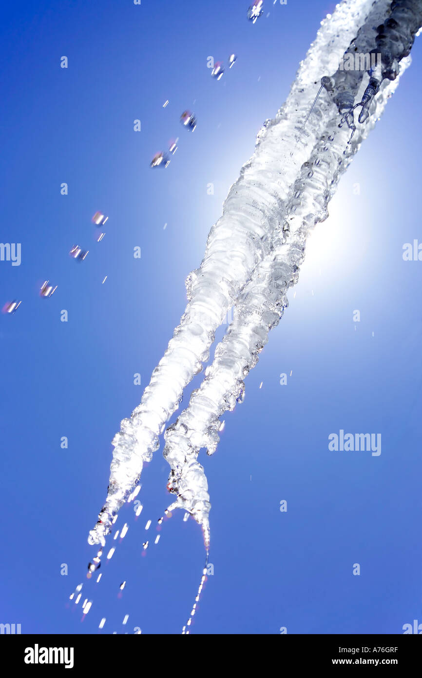 A melting icicle against the sun and a clean blue sky. Stock Photo