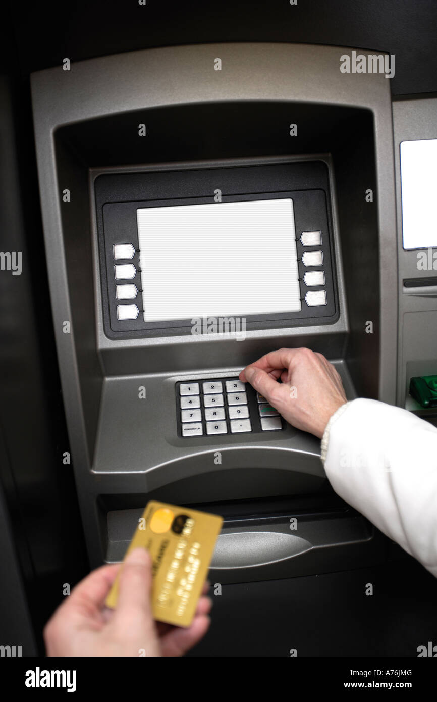 Person holding credit card, using ATM machine Stock Photo