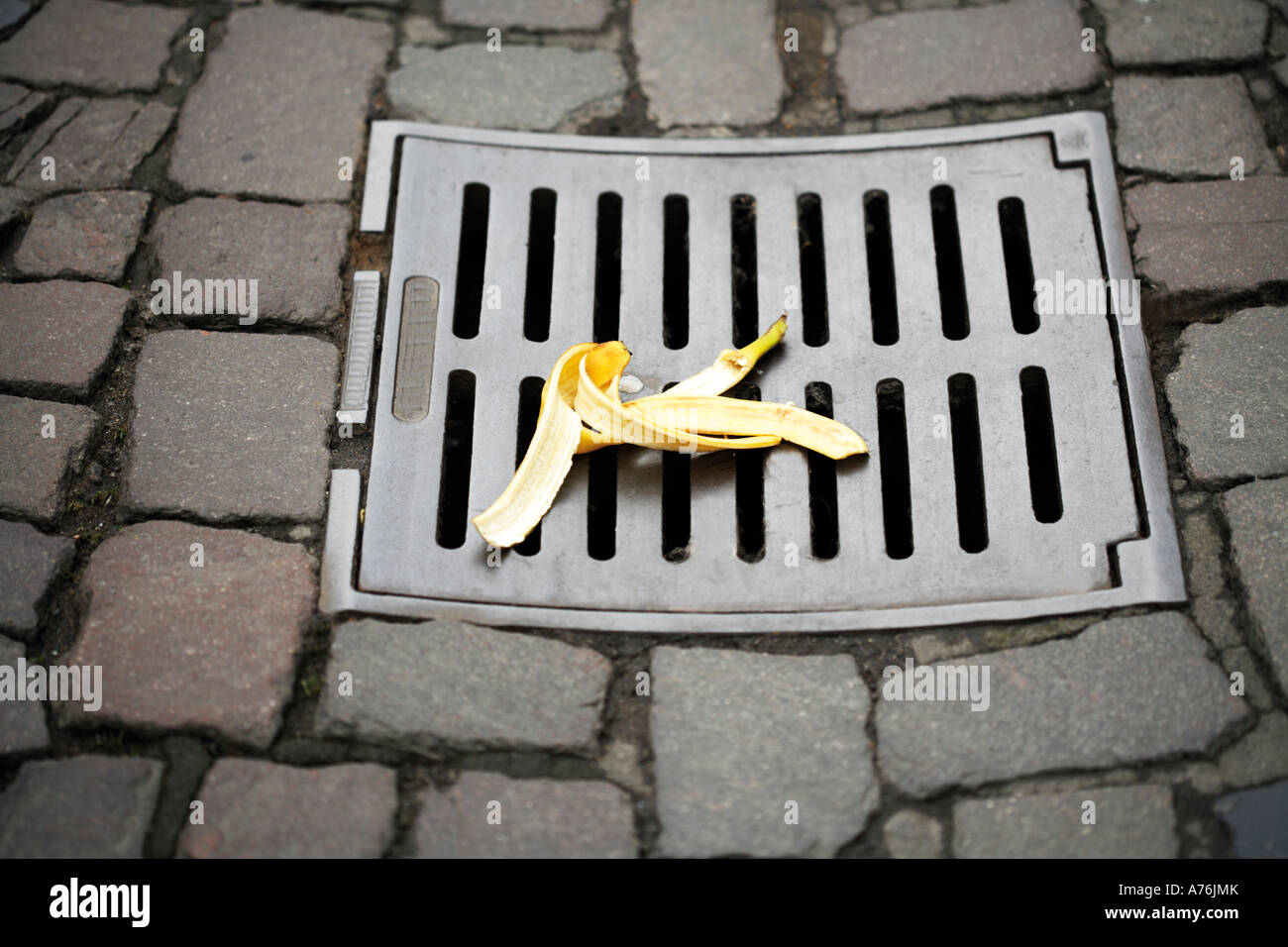 Banana peel on manhole cover, elevated view Stock Photo