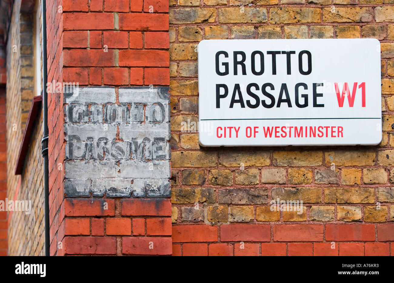 Two signs, old and new. Grotto Passage placed high on red brick building Marylebone, London, W1. Stock Photo