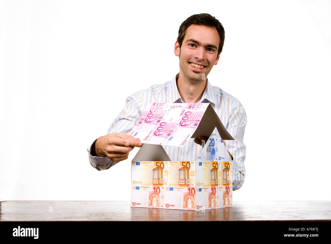 Young man with house of Euronotes Stock Photo