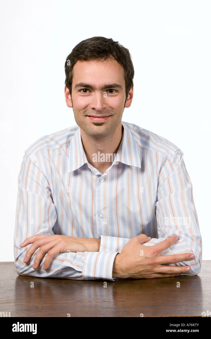 Young man sitting on table Stock Photo - Alamy