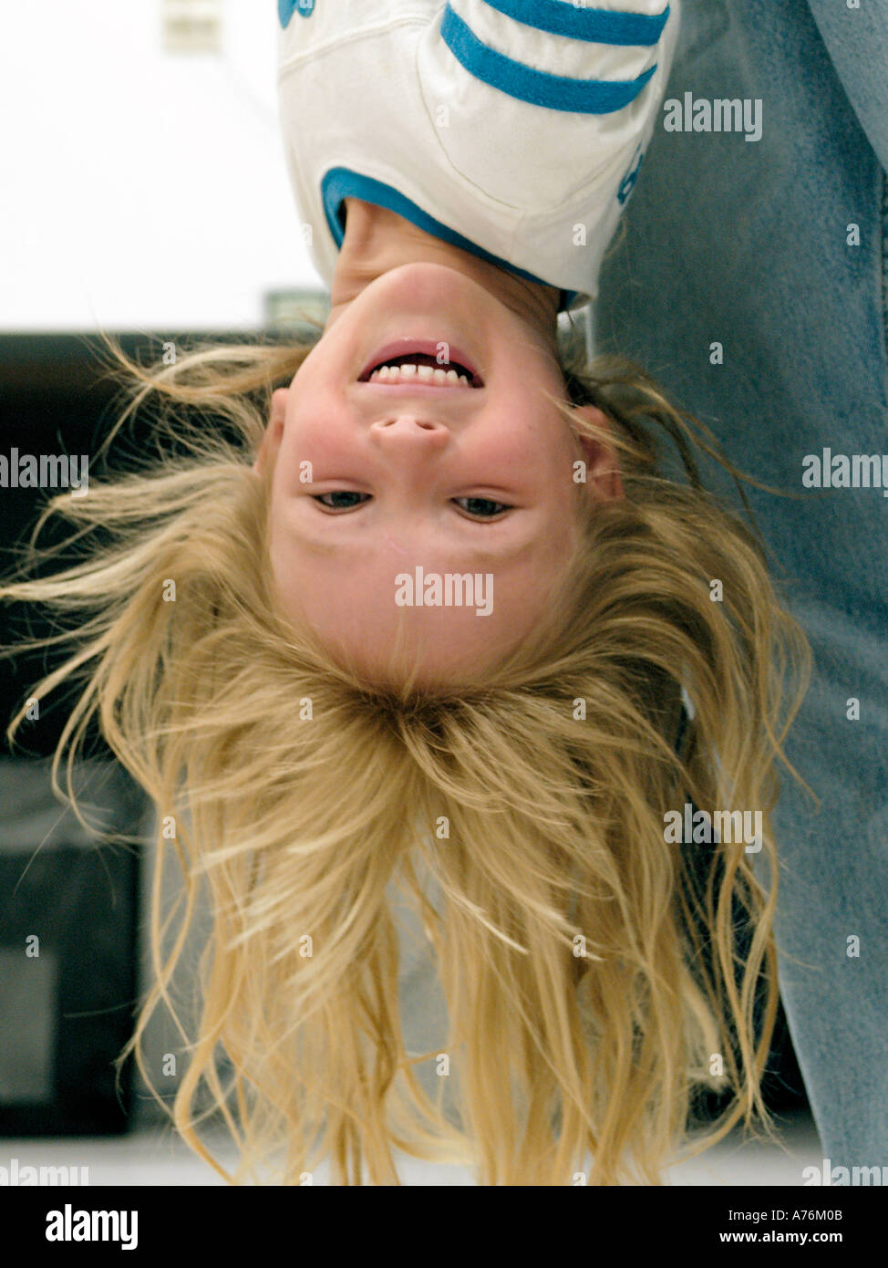 Little Girl With Long Blonde Hair Being Held Upside Down Stock