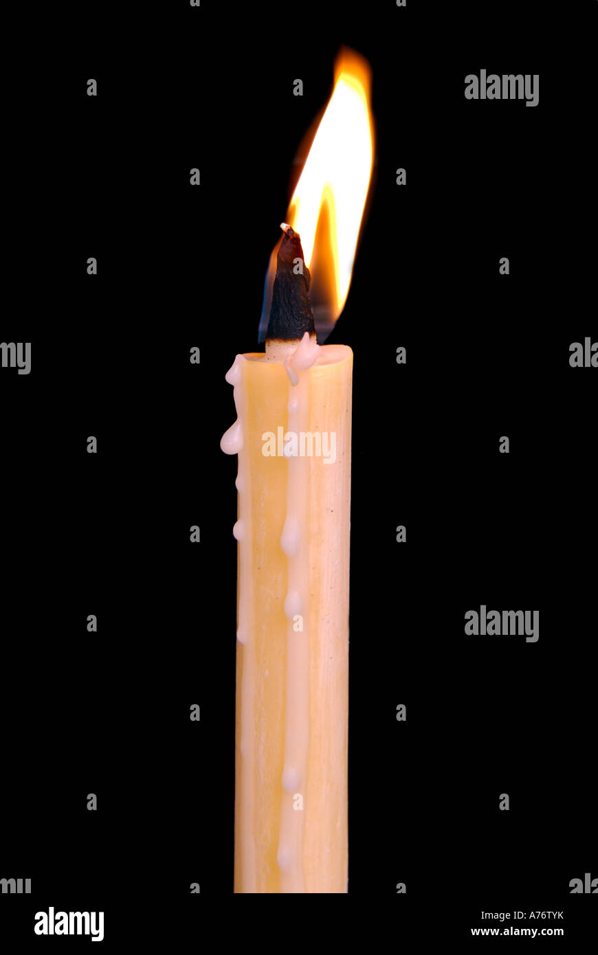 Single burning candle against a black background Stock Photo