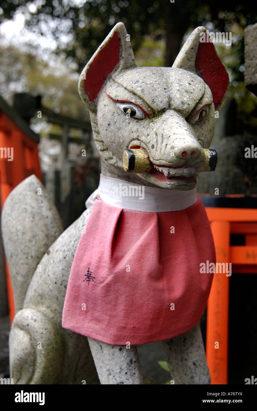 Stone sculpture of a fox with red bib Inari statue Fushimi Inari Taisha