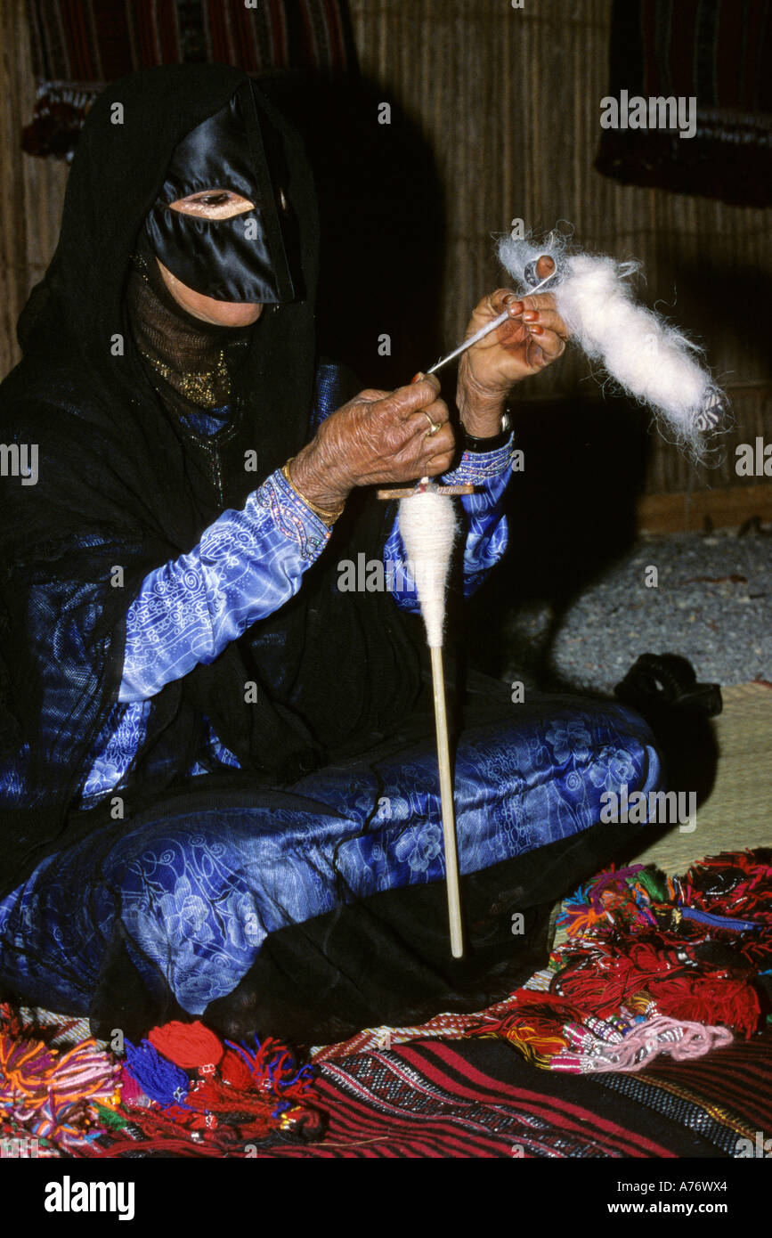 Omani Bedouin woman spinning wool, Muscat, Oman Stock Photo