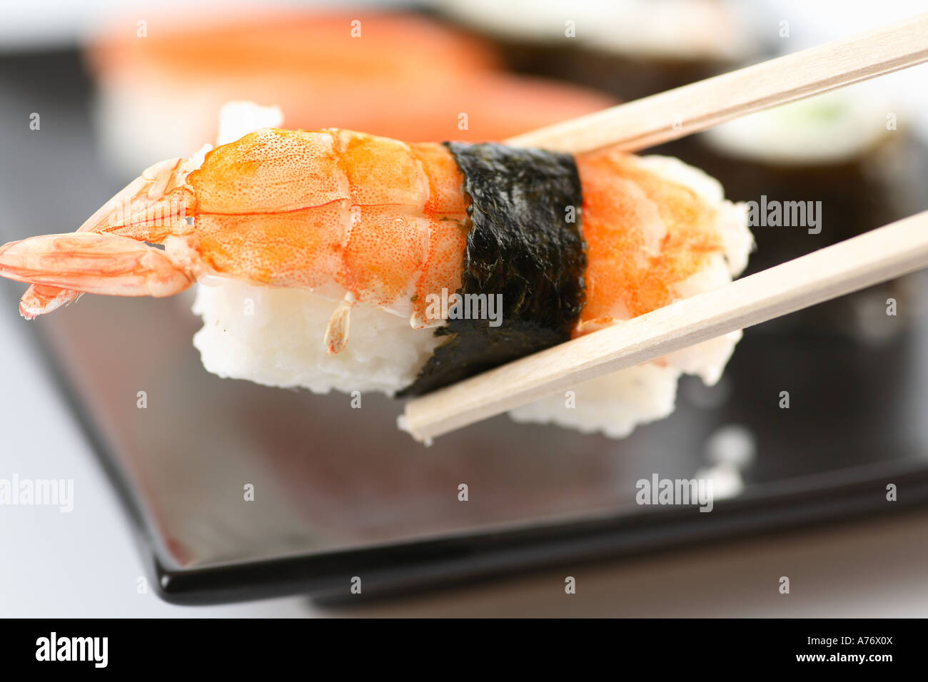 Sushi on chop sticks Stock Photo