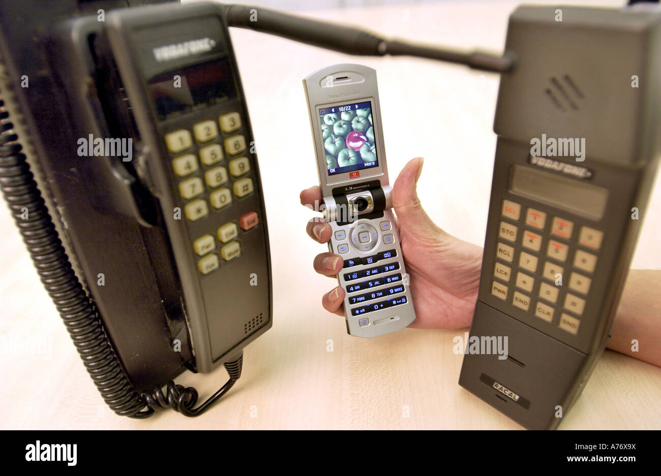 The history of mobile phones displayed with old models from the 1980s and a 3G videophone from 2004. Stock Photo