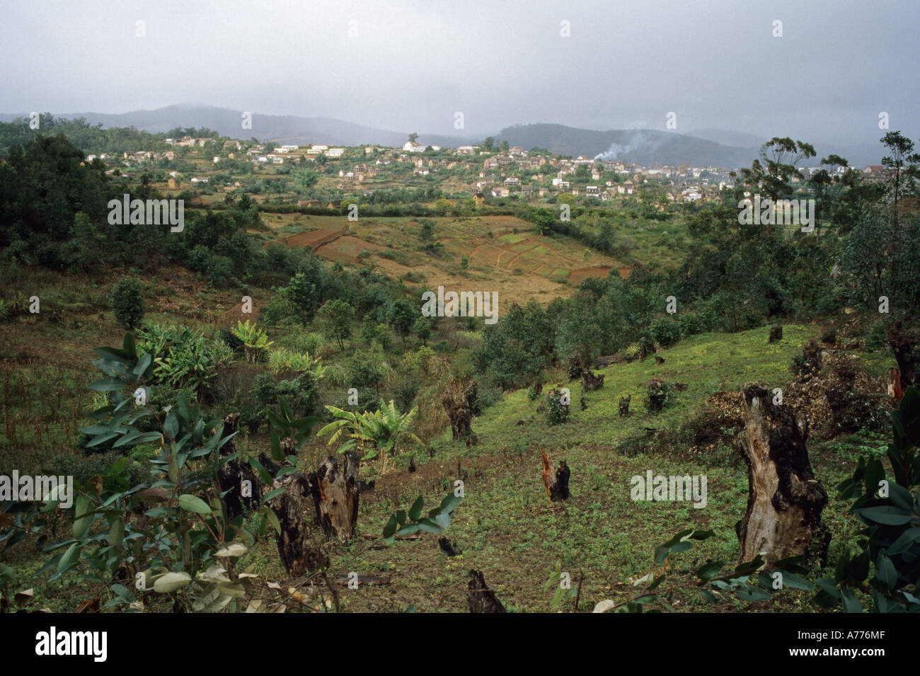 Deforested hills in central Madagascar with small town in distance Stock Photo