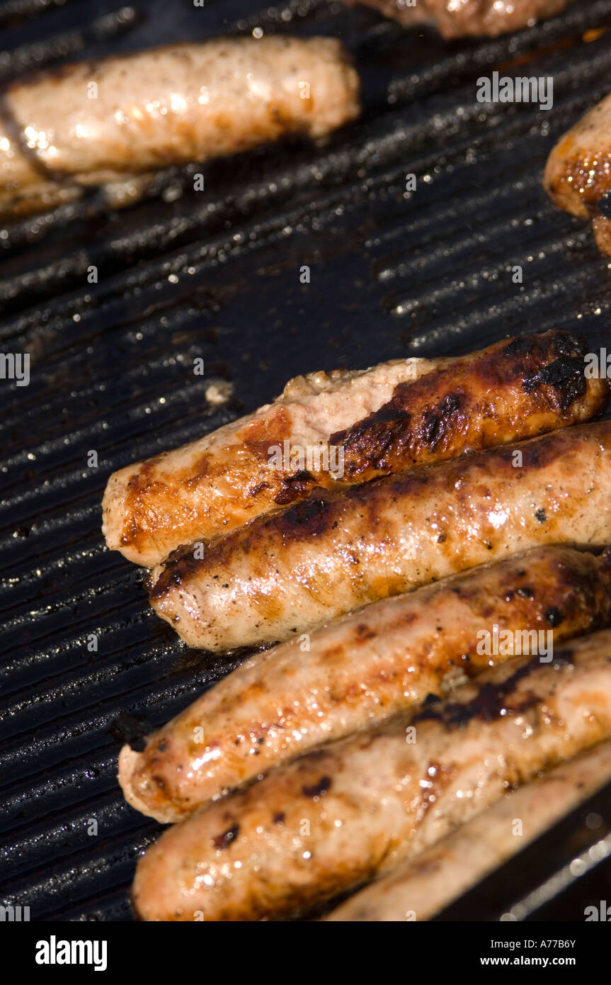 Sausages cooking on barbecue Bar-B-Q summer afternoon Stock Photo