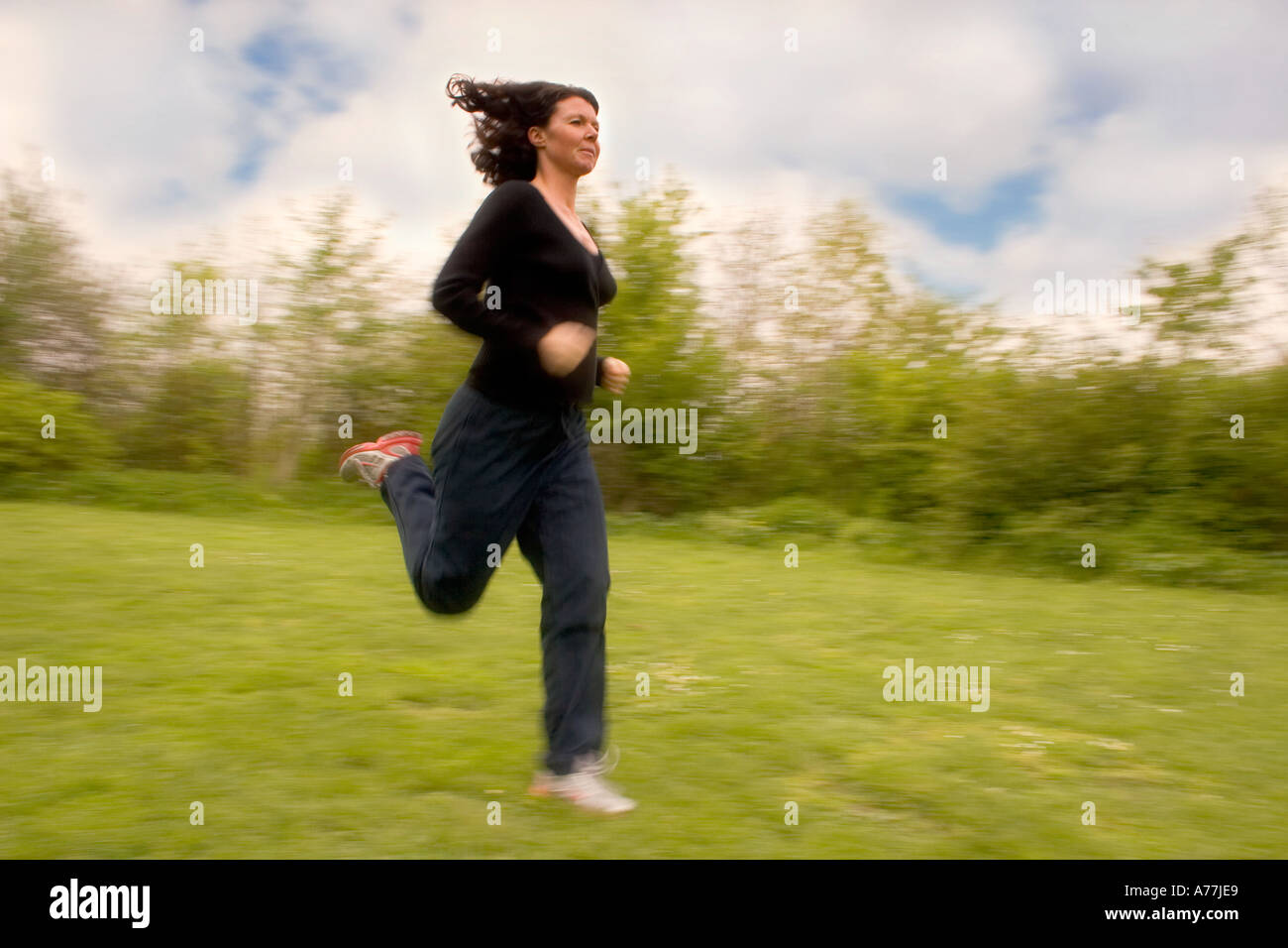 A young athletic woman running in the park Stock Photo