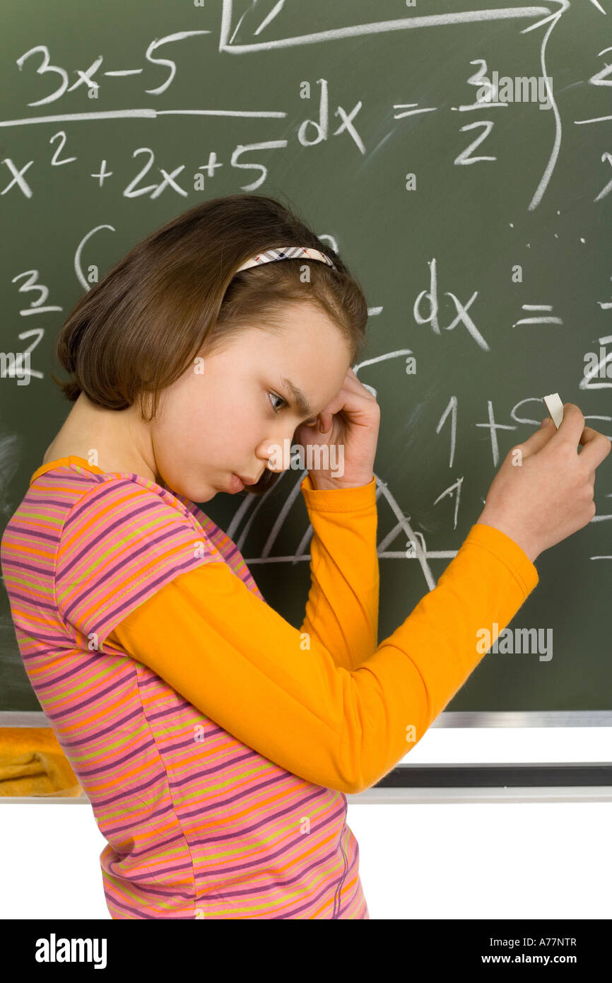 girl 11yo 11yo girl are standing with chalk in hand Looks thinking Next to her there  s greenboard with maths Stock Photo - Alamy