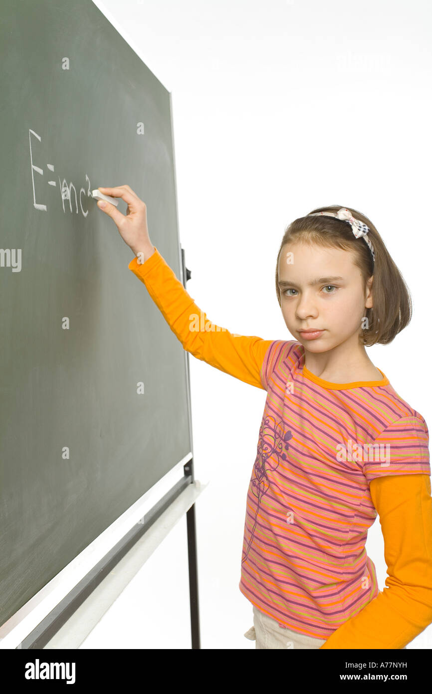 girl 11yo 11yo girl is standing with chalk in hand at greenboard She s just finished  writing E mc2 Stock Photo - Alamy