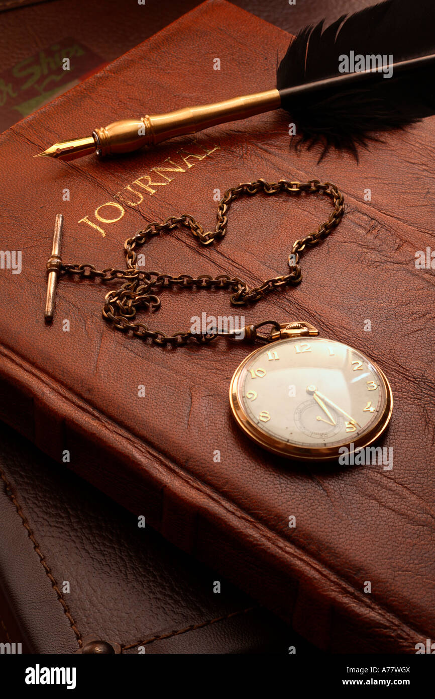 Antique pocket watch, leather bound journal and quill Stock Photo
