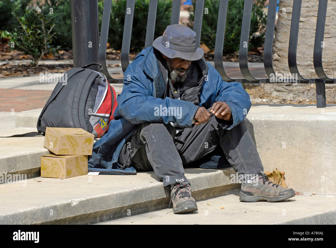 Homeless Person sitting on the edge of a cement curb in Orlando Florida