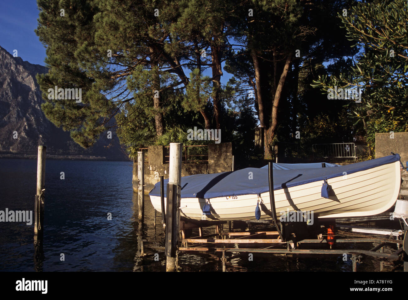 a small boat pulled up above the Lake Ceresio during the winter Switzerland Stock Photo