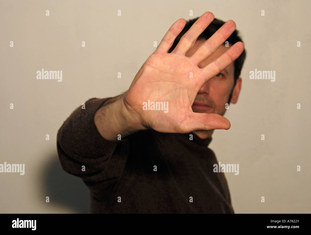 young man holding up his hand blocking photographer camera Stock Photo