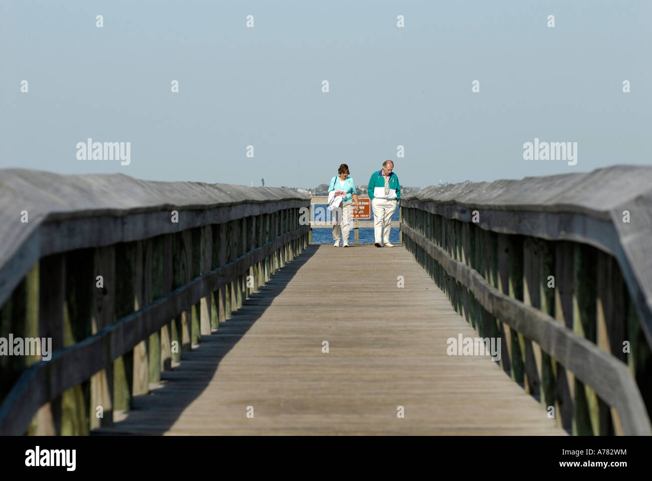 An adult couple walks on the city pier in the Gilchrist city park in