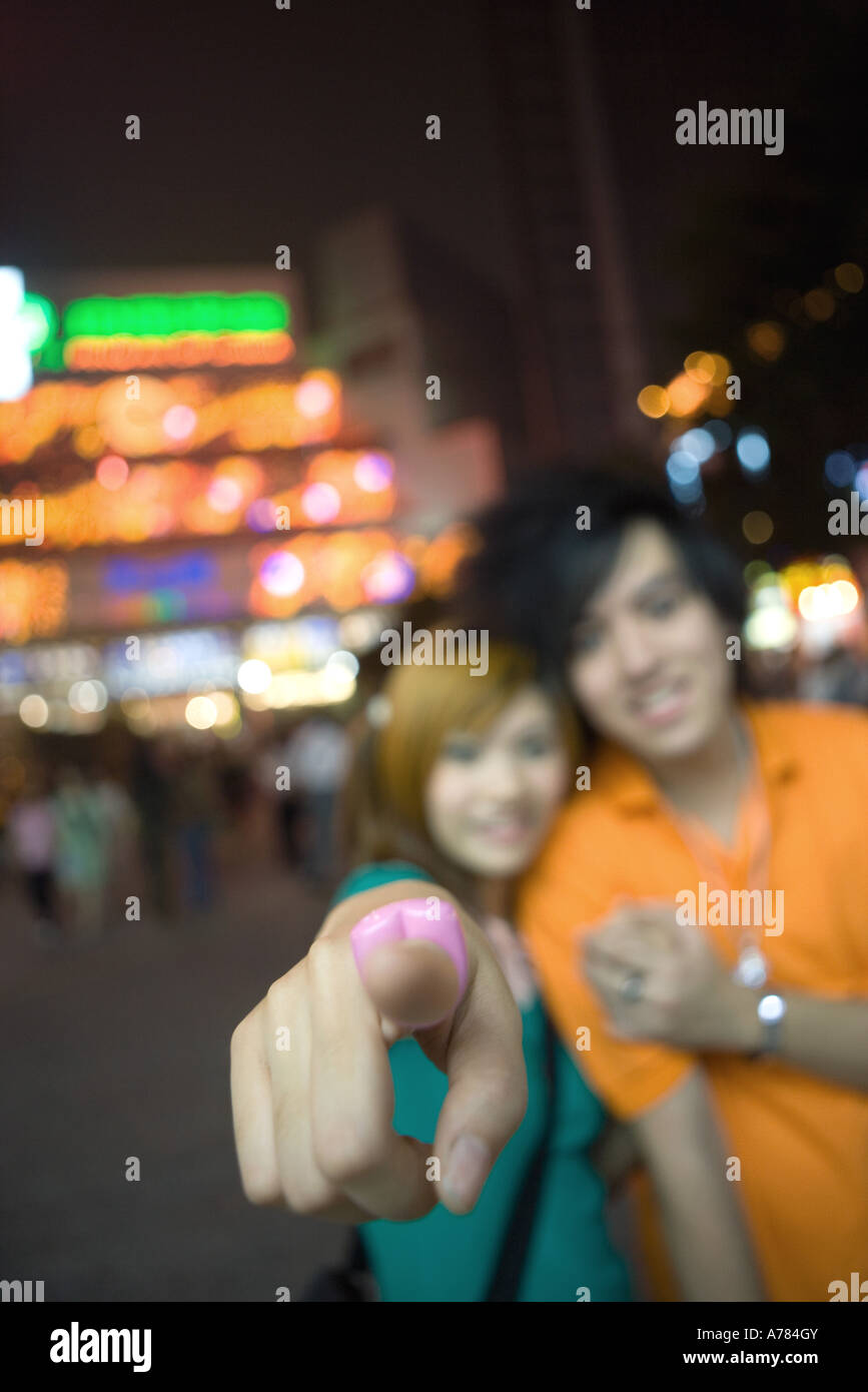 Teenage couple, focus on girl's finger pointing at camera Stock Photo
