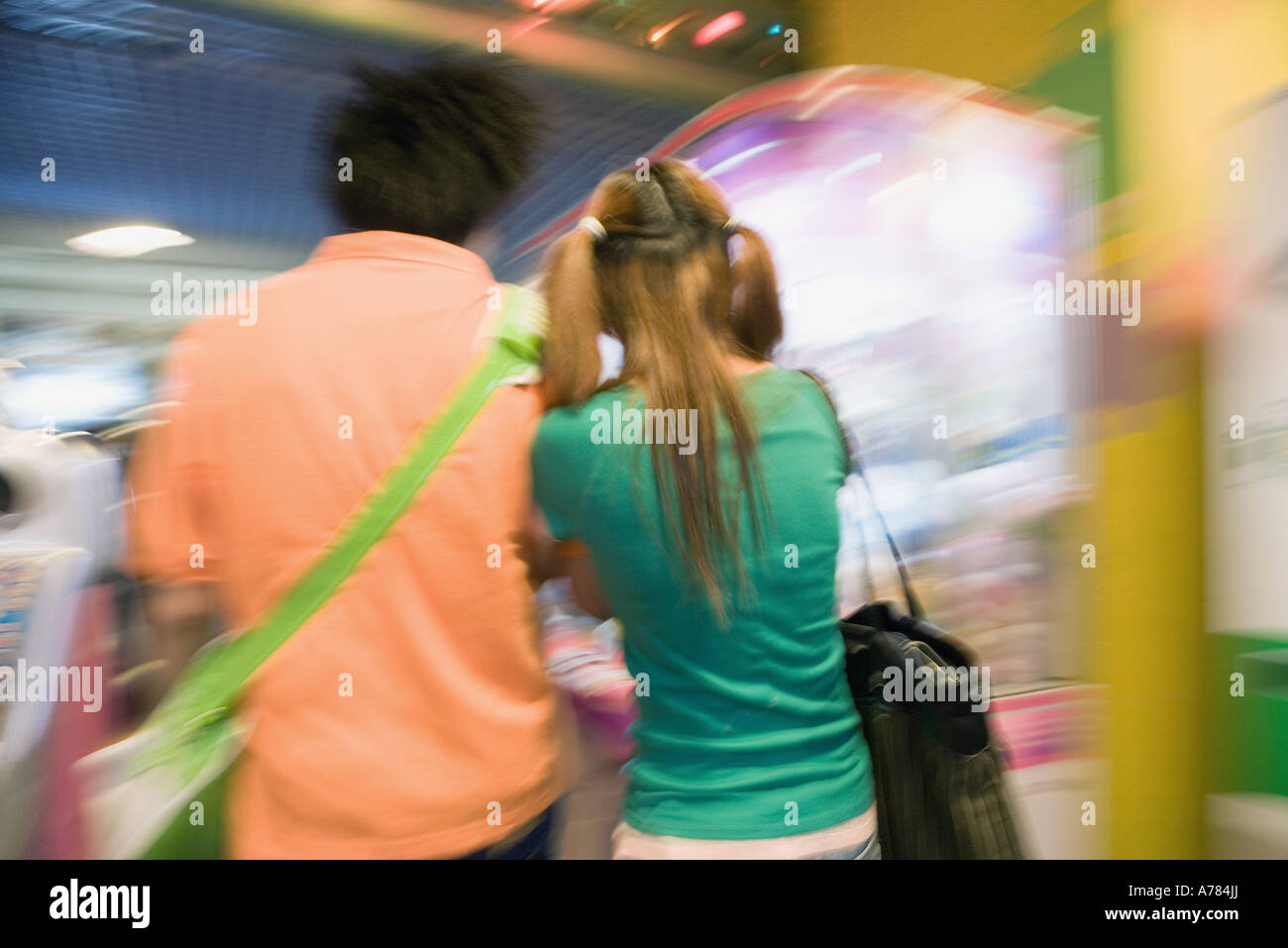 Teenage couple walking in video game arcade Stock Photo