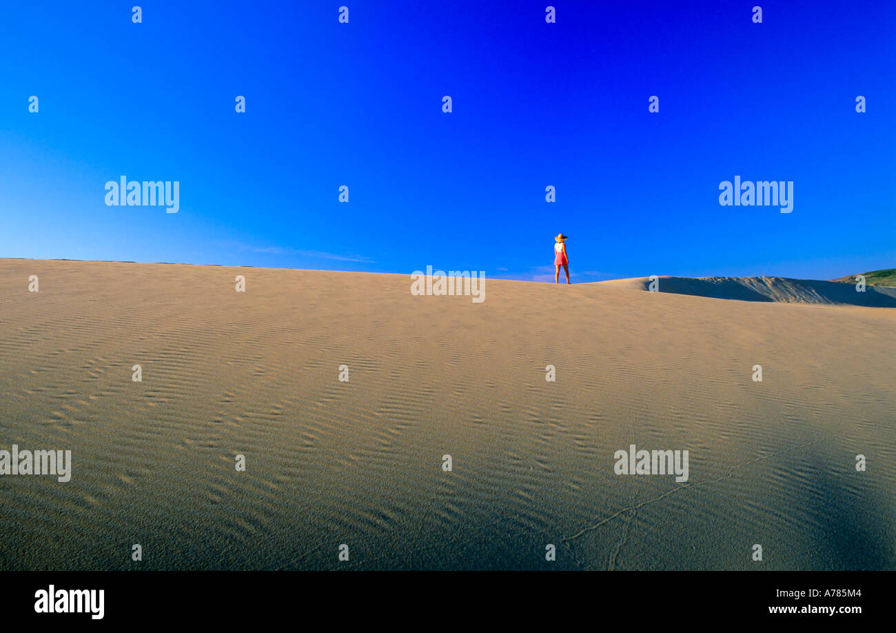 Woman walking along the dunes of Praia da Bordeira, Carrapateira, Natural Park Costa Vicentina, Algarve Portugal Stock Photo