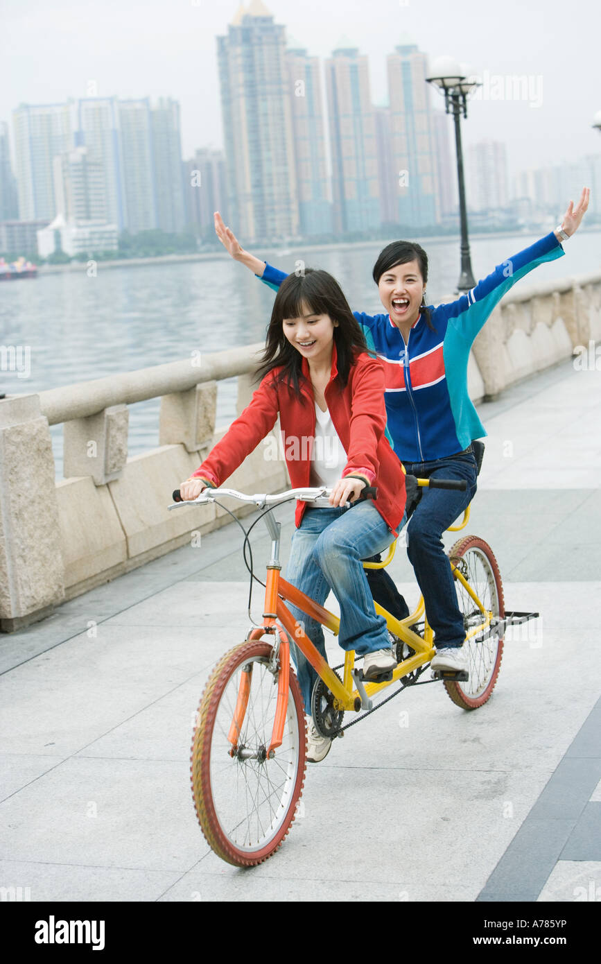 Two friends riding tandem bicycle Stock Photo Alamy