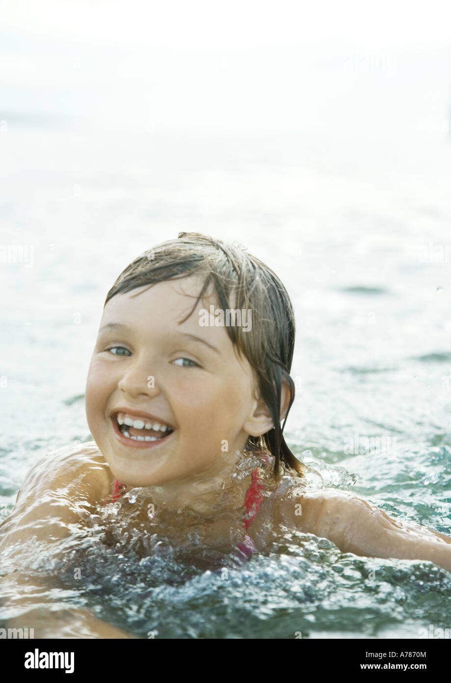 Girl wading in sea, smiling at camera Stock Photo Alamy
