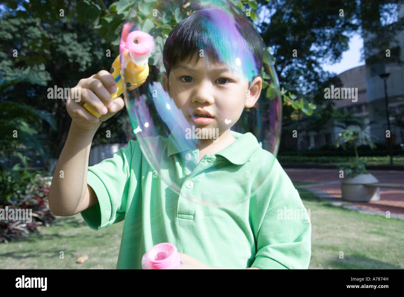 Boy making bubbles with bubble wand Stock Photo