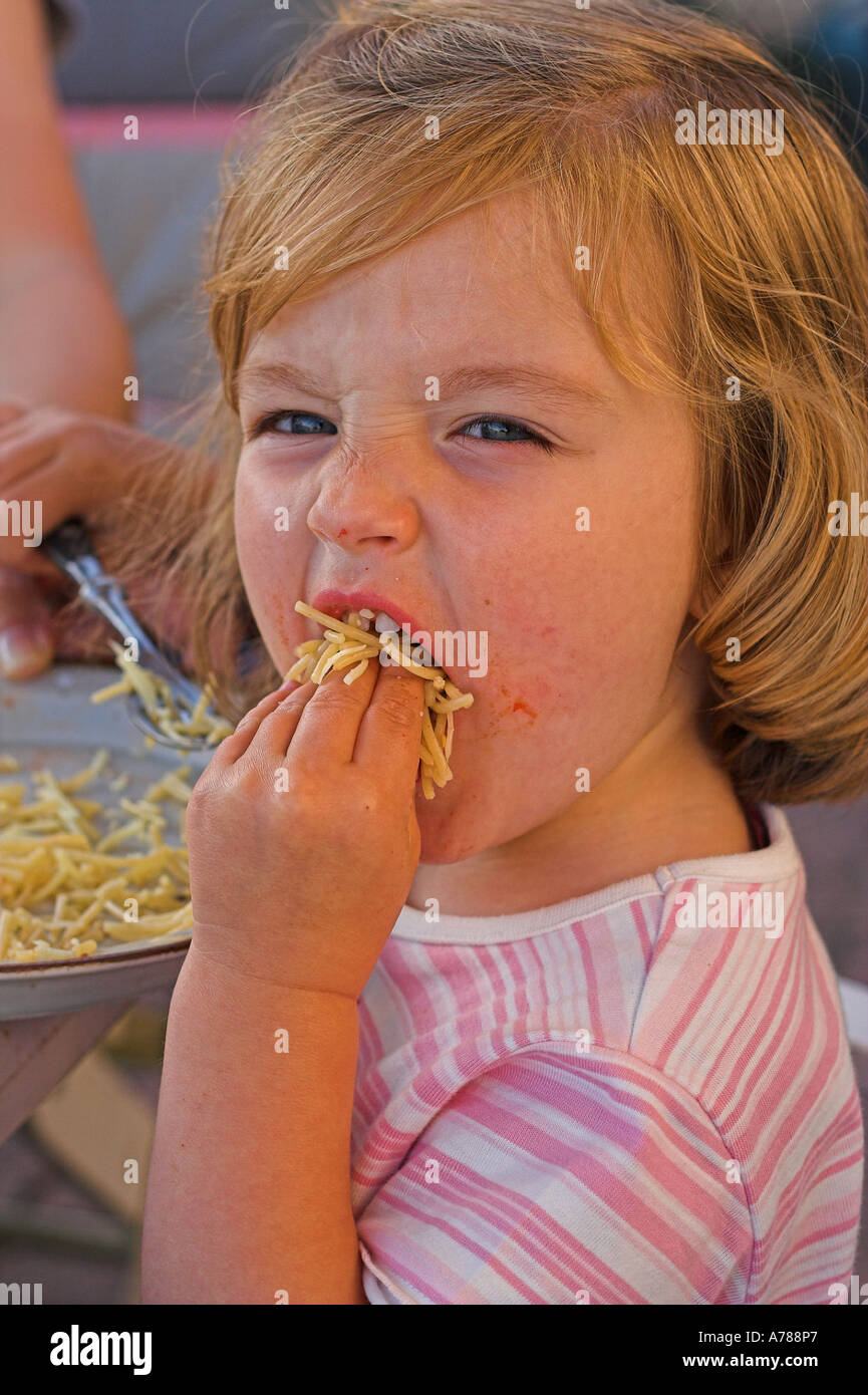little girl stuffing her face with food Stock Photo