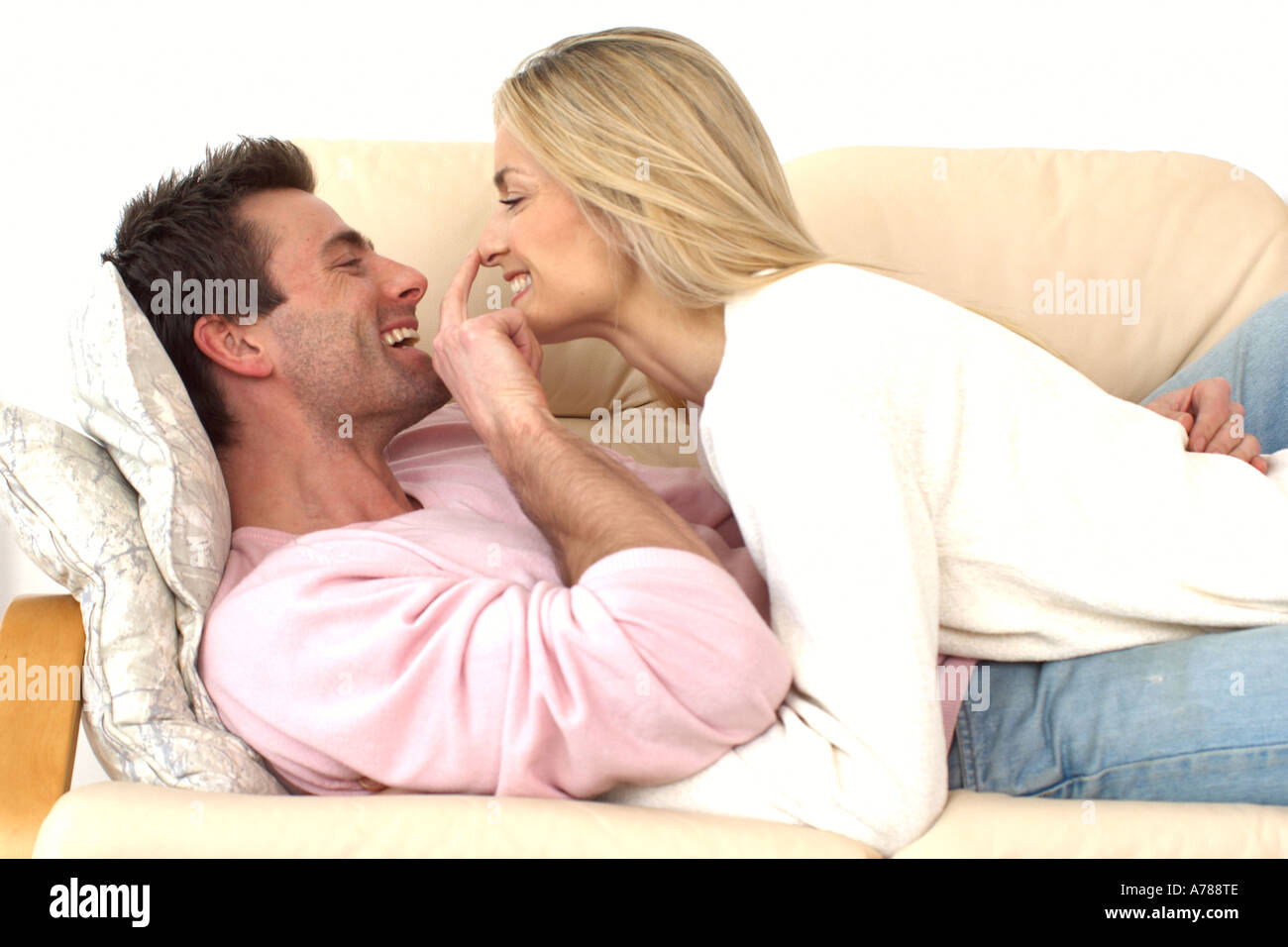 couple cuddling up on a sofa Stock Photo Alamy