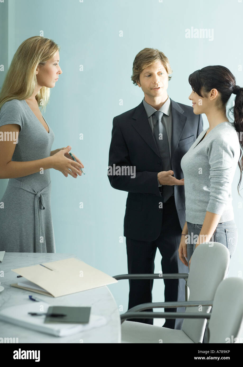 Businessman introducing teenage girl to young professional woman Stock Photo