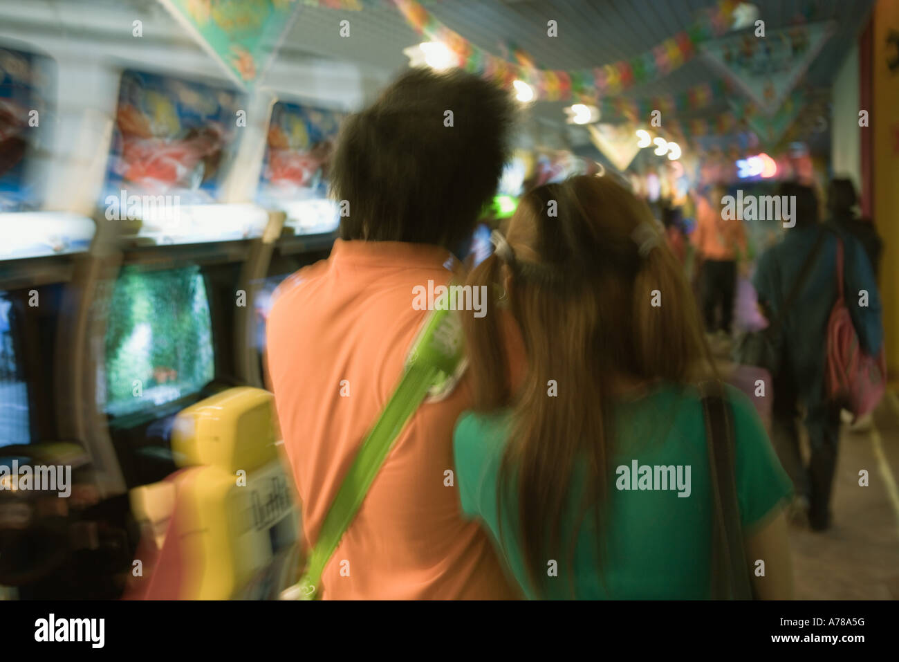 Young couple walking in video arcade, rear view Stock Photo - Alamy