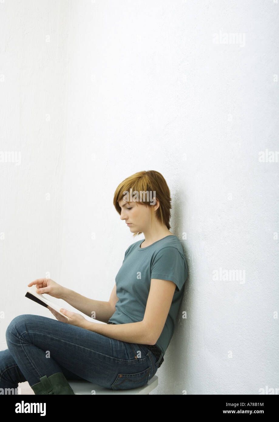 Young woman reading book, white background Stock Photo