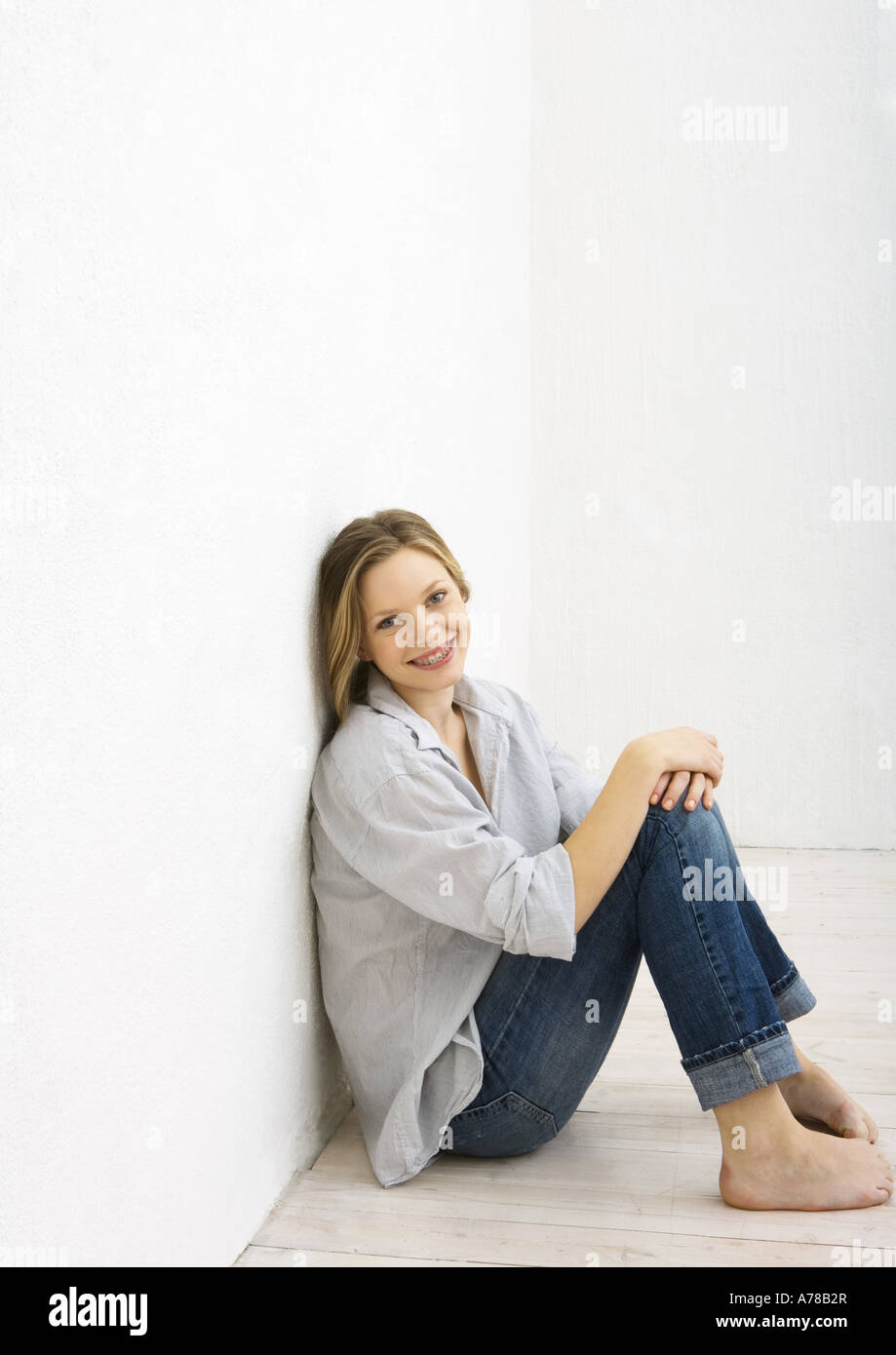 Teenage girl sitting on floor, smiling at camera, portrait Stock Photo ...