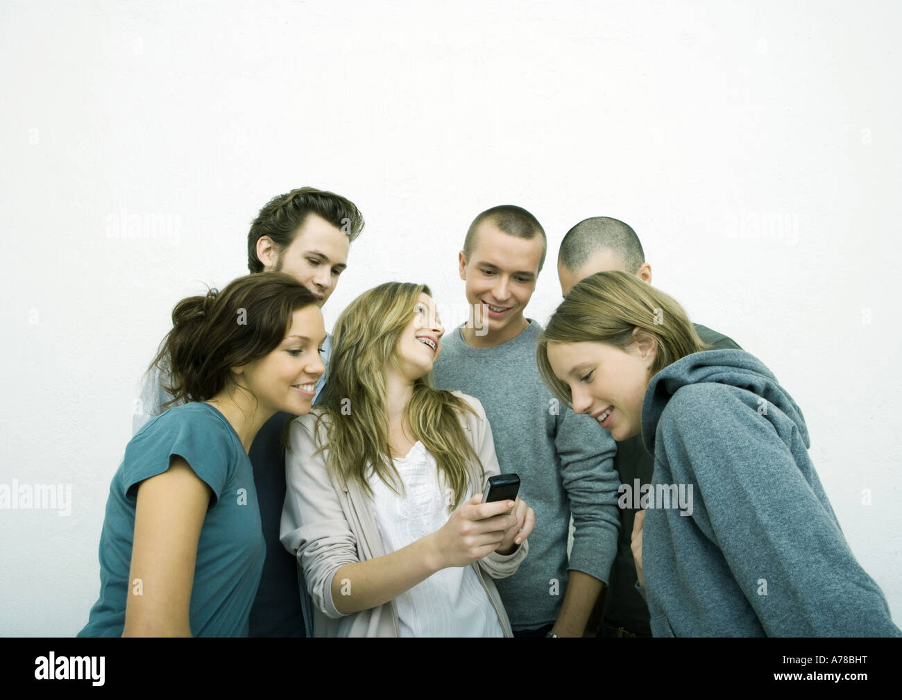 Group of young adult and teenage friends looking at cell phone, white  background Stock Photo - Alamy