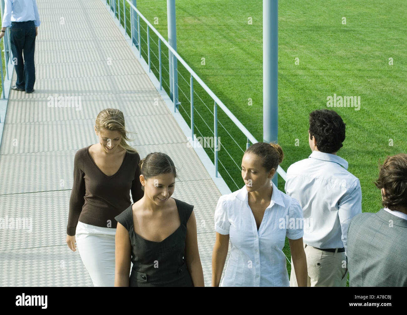 Young professionals walking and standing on walkway Stock Photo