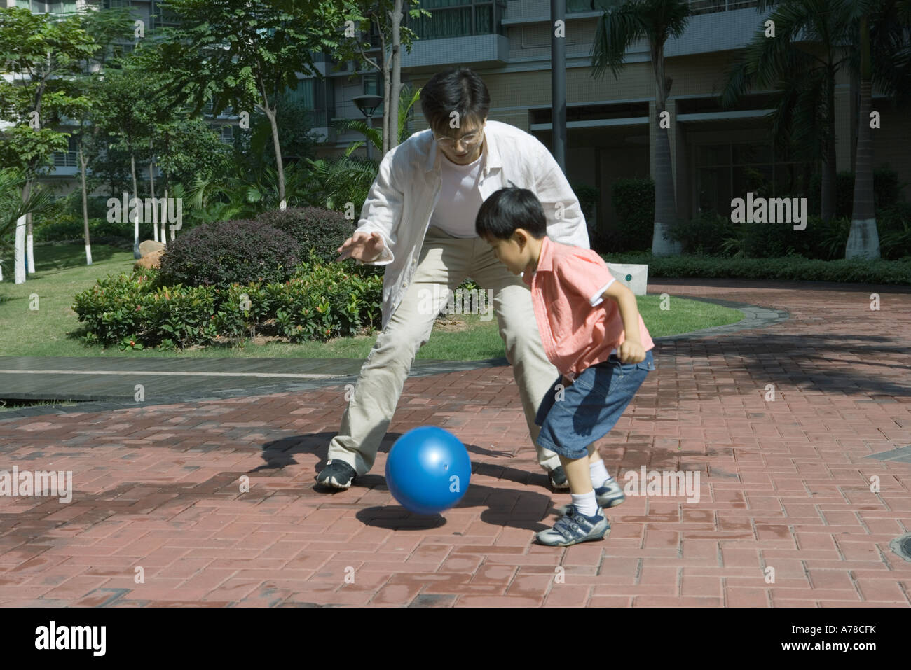 Father and son playing ball in courtyard Stock Photo - Alamy